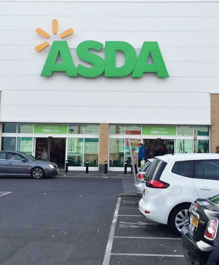 Front view of ASDA supermarket with cars parked in the foreground in a UK car park setting