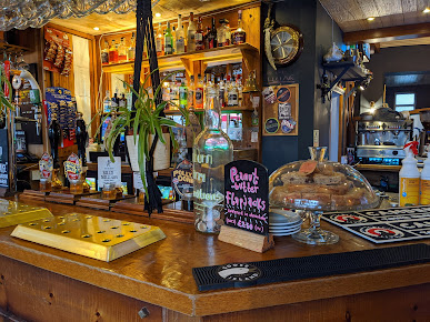 Cosy pub bar interior with drinks, snacks and decor in warm lighting, featuring a variety of ales and spirits