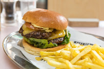 Delicious beef burger with lettuce, cheese, and tomato served on a plate with crispy chips in a casual dining setting